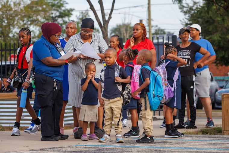 Kimberly Peterson (second from left) gets information about classrooms for her children as she arrives for the first day of classes at Bluford Elementary School in West Philadelphia last year.