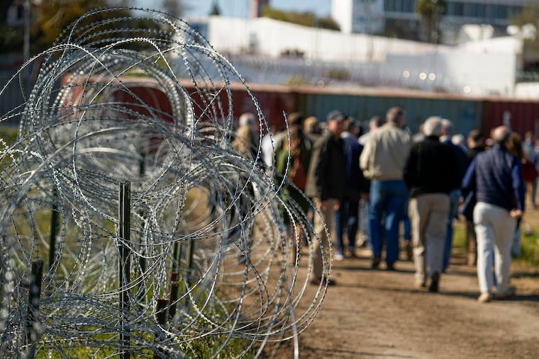 Concertina wire lines the path as members of Congress tour an area near the Texas-Mexico border, Jan. 3, 2024, in Eagle Pass, Texas.