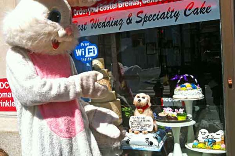 The Easter Bunny - played by Johnny McDermott - points to some of the goodies at the front window of Potito's Bakery's new location at 1315 Walnut Street. The shop enjoyed brisk sales on Saturday, the day before Easter. (By Suzette Parmley)