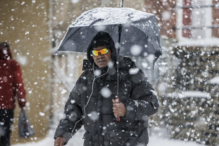 A pedestrian in Germantown among those giant snowflakes on Wednesday. MICHAEL BRYANT / Staff Photographer