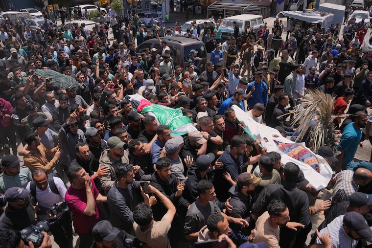 Palestinians carry the bodies of Izz al-Din al-Haddad, the leader of Hamas' Qassam Brigades, center, along with those of his daughter, right, and wife, who were killed in an Israeli strike, during their funeral in Gaza City, Saturday, May 16, 2026.