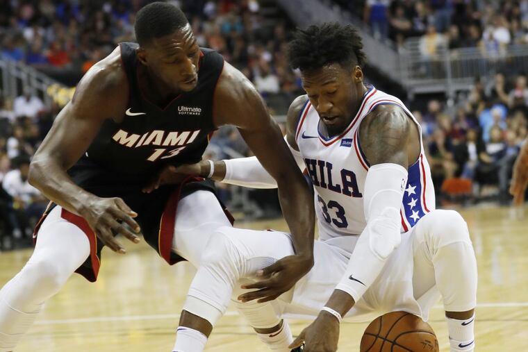 Miami Heat forward Bam Adebayo (left) attempts to steal the ball away from 76ers forward Robert Covington during the third quarter of an NBA preseason basketball game in Kansas City, Mo.