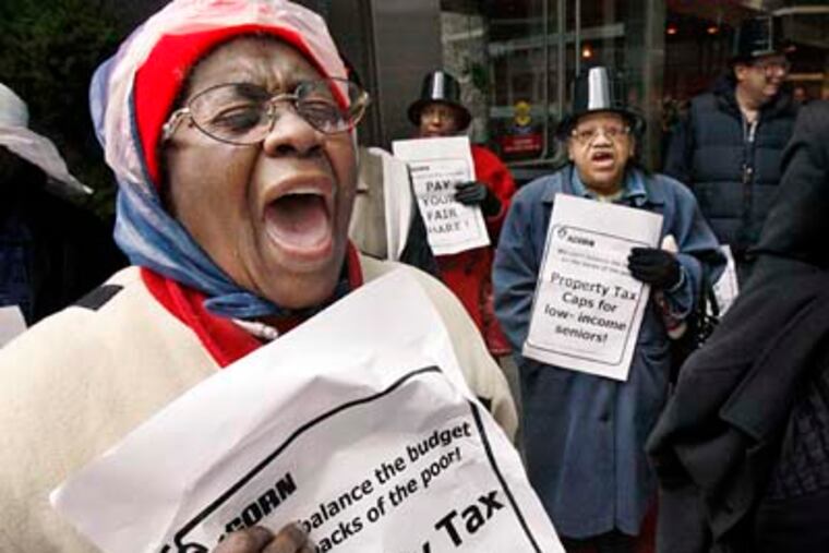 Evelyn Gibson of South Phila. (left) expresses her tax abatement displeasure along with other ACORN members during a protest at The Residences at Two Liberty Place on Wednesday. (Elizabeth Robertson / Staff Photographer)