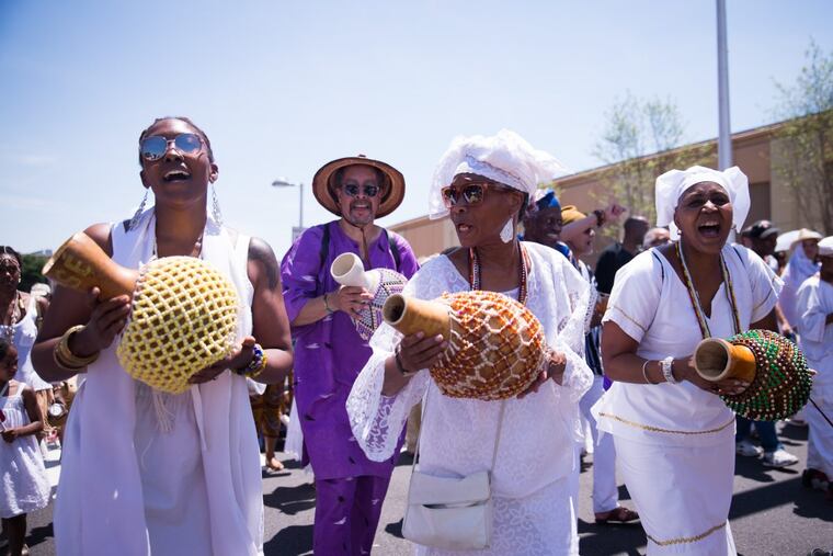 Three musicians process down South Street during the Odunde festival, June 11th, 2017.