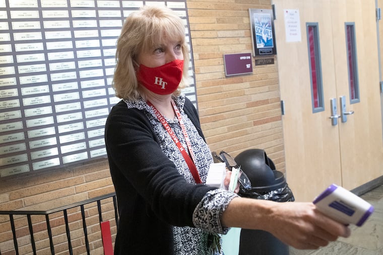 Kathy McCutcheon, a school nurse at Haddon Township High School, takes a temperature at the door during a remote learning school day on Wednesday, Nov. 25, 2020. Haddon Township High School has alternate days of remote learning and in-person instruction. This may change, as coronavirus cases are spiking in Camden County.