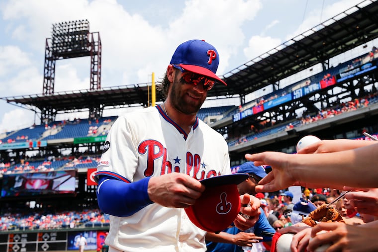 Phillies right fielder Bryce Harper signs his autograph for fans before the Phillies played the San Diego Padres on Sunday in Philadelphia.
