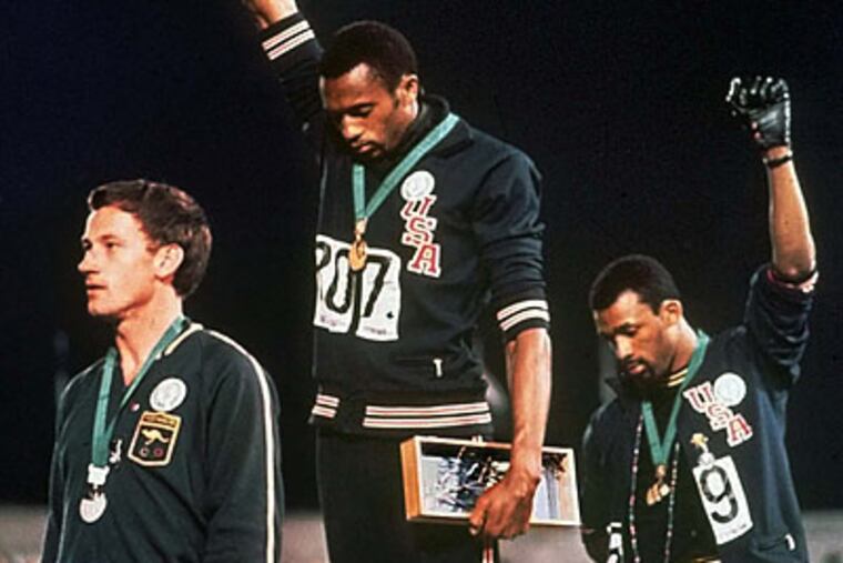 Tommie Smith (center) and John Carlos (right) on the medal podium in Mexico City 40 years ago. (AP file photo)