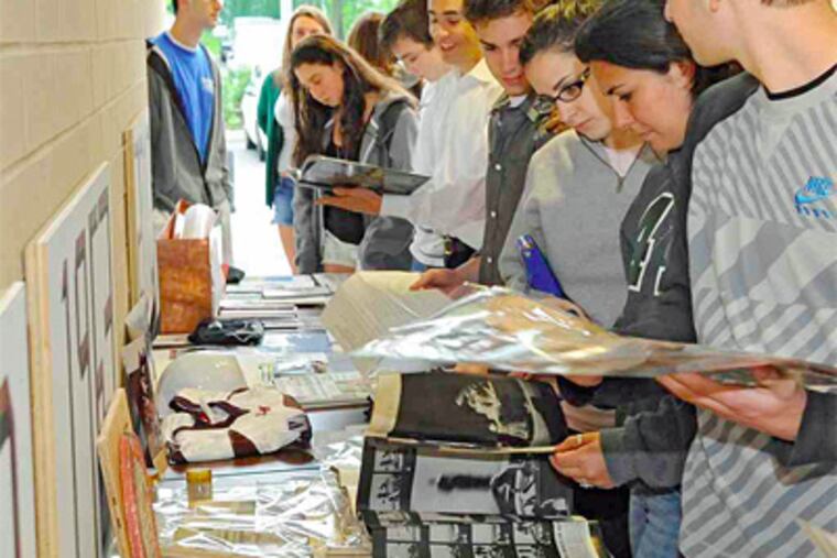 Lower Merion High School students examine time-capsule items - both those from 1910 and current items to be left for students to examine similarly decades from now. (Clem Murray / Staff Photographer)