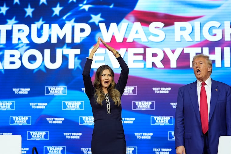 Republican presidential nominee former President Donald Trump watches as South Dakota Gov. Kristi Noem dances to the song "YMCA" at a campaign town hall at the Greater Philadelphia Expo Center & Fairgrounds, Monday, Oct. 14, 2024, in Oaks.