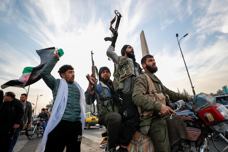 Syrian opposition fighters celebrate after the Syrian government collapsed in Damascus on Sunday.
