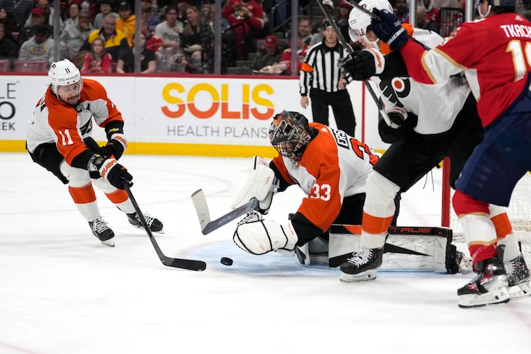 Flyers right wing Travis Konecny (11) and goaltender Samuel Ersson look to control the puck.