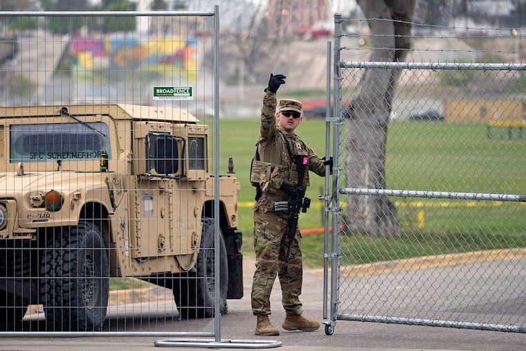 A member of the National Guard directs a vehicle at the gate to Shelby Park along the Rio Grande in Eagle Pass, Texas.