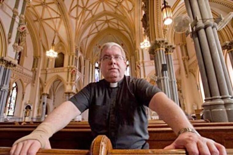 The Rev. James A. Lyons, pastor of St. John the Baptist Roman Catholic Church, in the pews of his Manayunk church. (David M Warren / Staff Photographer)
