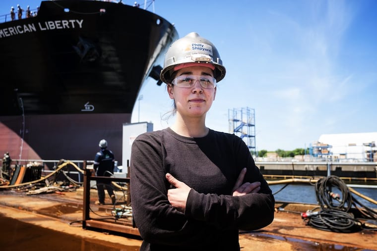 Samantha Toggas, Temple graduate and apprentice welder, at the Philadelphia shipyard in front of the project tanker ship "American Freedom," the 27th ship built at the yard.