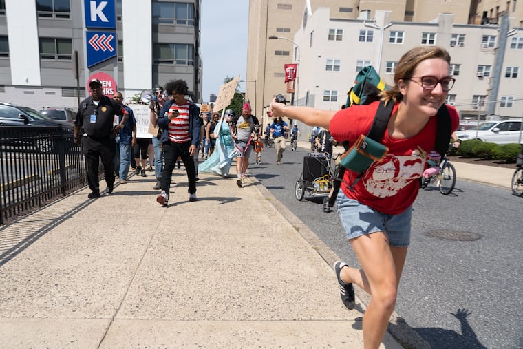 Becky Cave, a protest organizer. leads the charge with a "Naruto Run" as demonstrators march east on Cherry street outside the ICE field office in Philadelphia on Saturday.