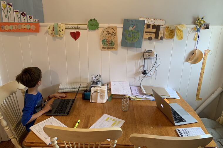 At one end of the kitchen table, the coronavirus "home office" of columnist Maria Panaritis, with Mac laptop and pile of papers. On the other, her first-grade son attempts classwork on a Chrome Book since the coronavirus pandemic has shut down schools in Pennsylvania.