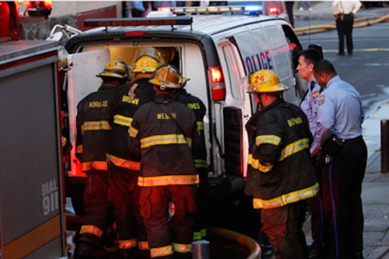 The body of a victim in this morning's predawn blaze is placed into a police van. The fire at 5250 Chancellor St in West Philadelphia killed four people, including two children. ( ALEJANDRO A. ALVAREZ /
STAFF PHOTOGRAPHER )