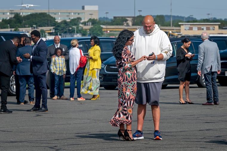 U.S. Sen. John Fetterman and his wife Gisele Barreto Fetterman await the arrival of then-President Joe Biden on Marine One at Philadelphia International Airport July 7, 2024.