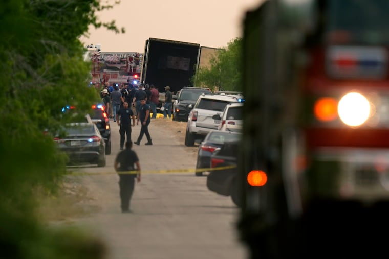 Body bags lie at the scene where a tractor-trailer with dead bodies was discovered Monday in San Antonio.