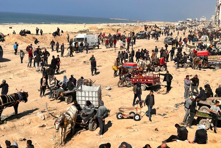Palestinians wait for humanitarian aid on a beachfront in Gaza City, Gaza Strip, on Sunday.