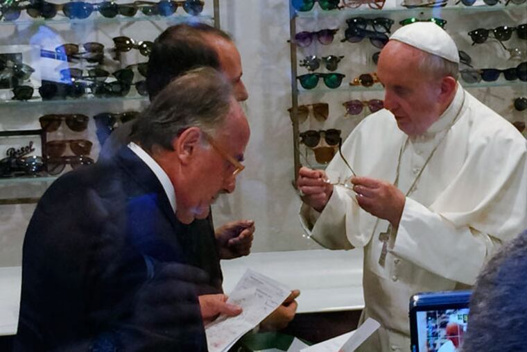 Pope Francis tries on glasses Friday. Anyone looking to catch a glimpse of Francis without the help of a Jumbotron should consider a pair of their own. (Daniel Soehne via AP)
