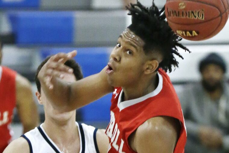 Archbishop Carroll’s AJ Hoggard (right) tries to grab a loose ball in the first half of Carroll’s state playoff win over Wissahickon on Thursday.