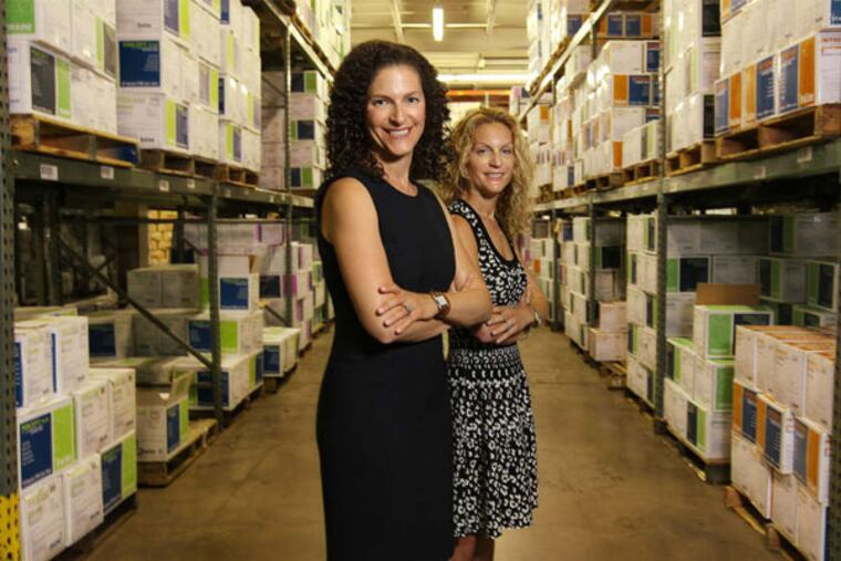 Julie Copeland (left), CEO of Arbill, with sister Robin Zlotkin, the executive vice president, in the company's North Philadelphia warehouse. (Michael Bryant / Staff Photographer)
