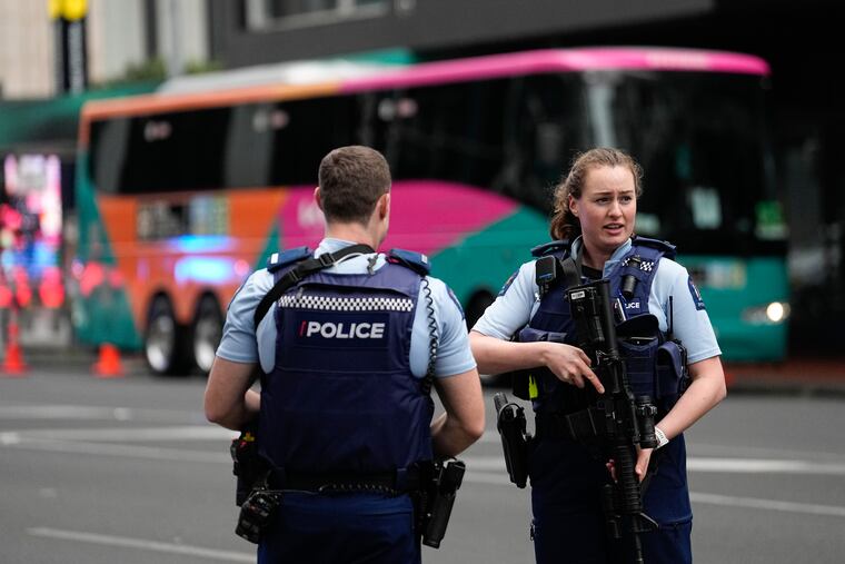 Armed New Zealand police officers stand outside a hotel housing a team from the FIFA Women's World Cup in the central business district following a shooting in Auckland, New Zealand, Thursday, July 20, 2023. New Zealand police are responding to reports that a gunman has fired shots in a building in downtown Auckland. (AP Photo/Abbie Parr)