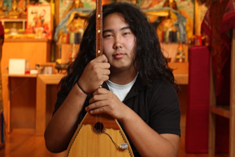 Alex Kalatschinow, 15, in a rock band, also enjoys playing the Dombr, a traditional two string instrument of the Kalmyk people. He will be in the sold-out crowd to hear the Dalai Lama speak at the Kimmel Center on Wednesday. (Michael Bryant / Inquirer)