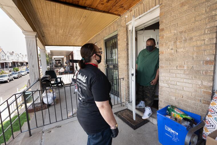 Maria Lozada, left, a treatment adherence specialist at Bebashi, is shown here with one of the clients she visits regularly, Darnell Starr, right, in Philadelphia, July 30, 2020.