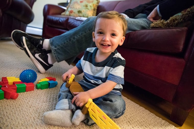 Patrick Higgins plays with his toys in his family's Newtown, Pa. living room. Patrick was adopted, his birth mother used opioids during her pregnancy.