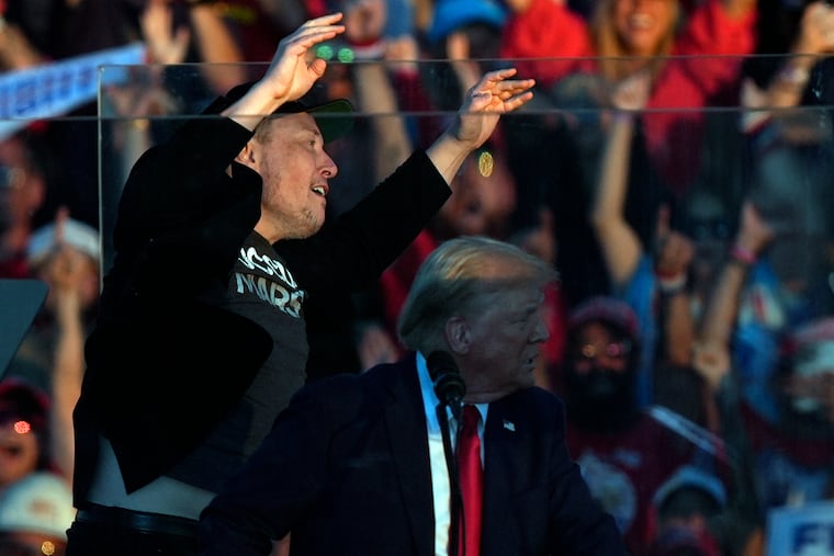 Elon Musk jumps on the stage behind Republican presidential nominee former President Donald Trump during a campaign rally at the Butler Farm Show on Saturday.