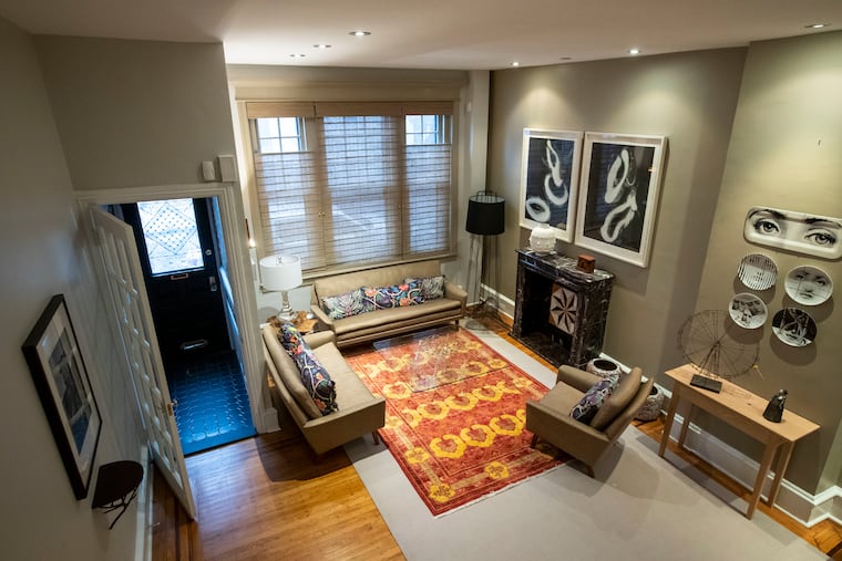 The colorful living room at Tamara Harris' home in Fitler Square features artwork she has collected and a decorative fireplace she had rebuilt from parts.