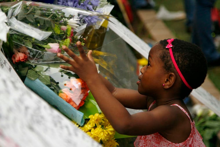 ASSOCIATED PRESS A young girl places flowers yesterday outside the home of the former South African president.