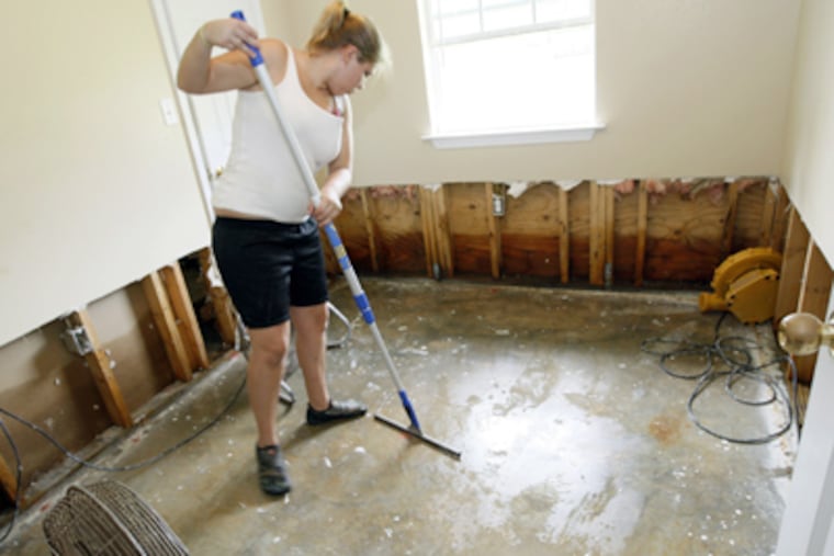 Kayrin White wipes down a bedroom floor in her parents' home in Bay St. Louis, Miss., in the aftermath of Isaac. The house took in almost two feet of water. (Rogelio V. Solis / Associated Press)