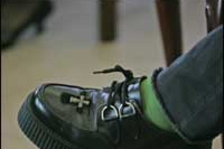 Bono's shoes are decorated with a cross. He wears a crucifix around his neck, a gift from Pope John Paul II in exchange for a pair of tinted glasses.