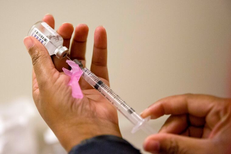 FILE - In this Feb. 7, 2018 file photo, a nurse prepares a flu shot at the Salvation Army in Atlanta. The flu forecast is cloudy and it’s too soon to know if the U.S. is in for a third miserable season in a row, but health officials said Thursday, Sept. 26, 2019 not to delay vaccination. (AP Photo/David Goldman, File)