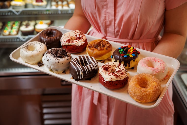 Katina Pantazopoulos of Tiffany’s Bakery with a tray of Doyos, the signature steamed cake doughnuts.