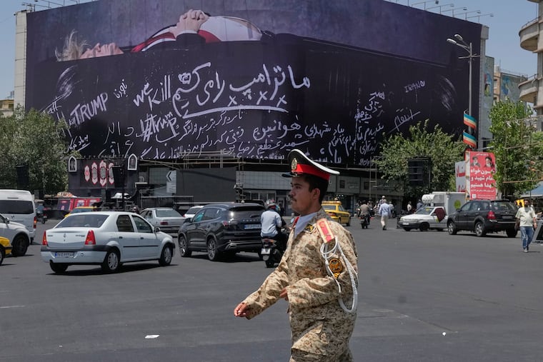An army cadet walks past a billboard bearing anti-Trump messages, including the phrase "We Kill Trump," at Islamic Revolution Square in downtown Tehran, Iran, Wednesday, July 15, 2026.