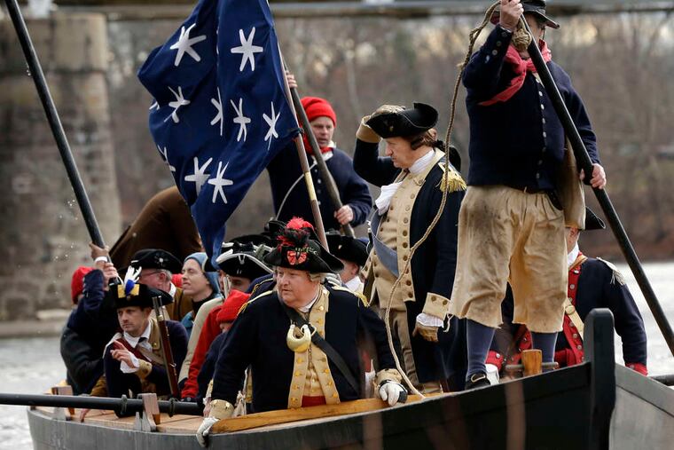 John Godzieba (holding his hat) plays Gen. George Washington crossing the Delaware between Washington Crossing and Titusville, N.J., joined by fellow reenactors playing his troops.