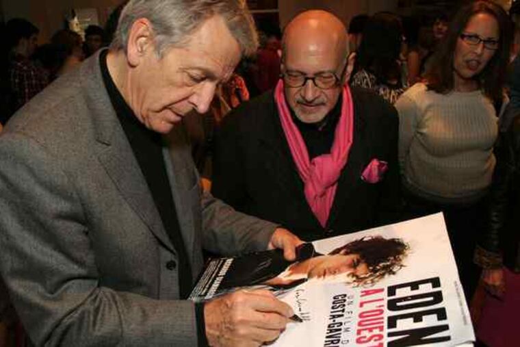 Director Costa-Gavras signs a poster at the premiere of "Eden Is West"at the Prince Music Theater while Thom Cardwell of the Philadelphia Cinema Alliance looks on. The alliance honored Costa-Gavras on Friday.