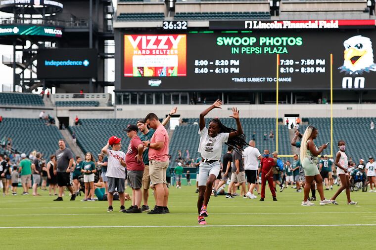 Azziyah Sharpe, 11, of North Philadelphia, runs on the Lincoln Financial Field turf before the Eagles practiced on Sunday. Fans were allowed on the field before the players practiced.