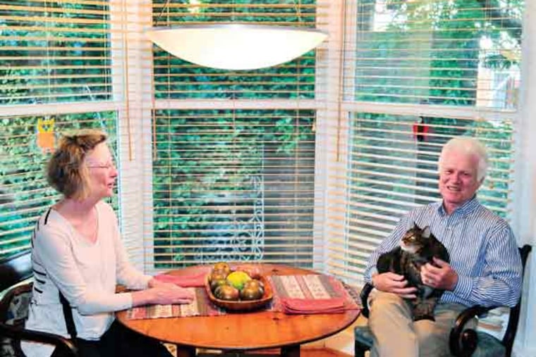 Missy and John Randolph chat with their cat at their dinette table that over looks the garden of their historic Center City townhouse on Monday, September 15, 2014. C.F. Sanchez / Staff Photographer