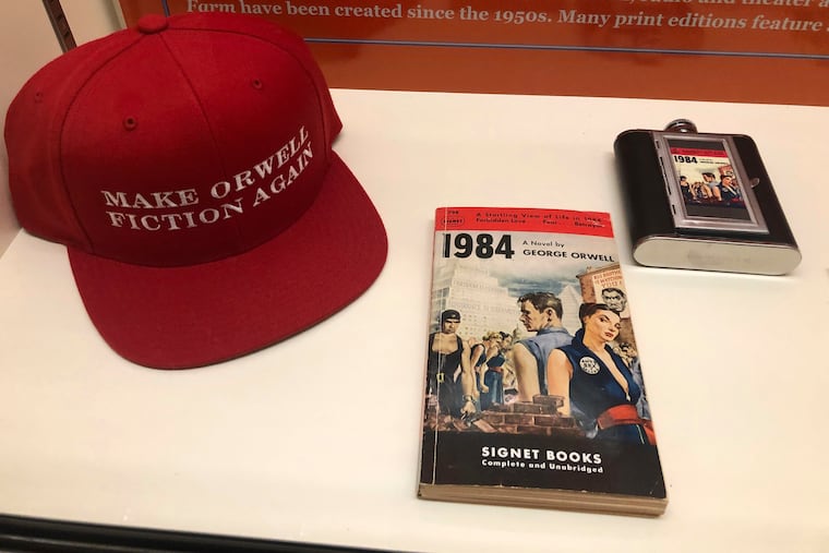 A vintage copy of George Orwell's 1949 novel "1984" next to a hat about Orwell is shown at a 2019 exhibit in Albuquerque, N.M., celebrating the author's legacy. Kathryn Grossman writes that we are today "sunk deep in the mire of doublethink, and of Orwellian dystopia in general."