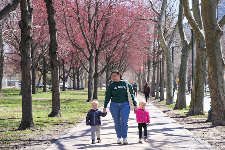 Warren, Ana Carolina Dias, and Winter, walk together along the Benjamin Franklin Parkway on a beautiful spring day on March 25, 2025.