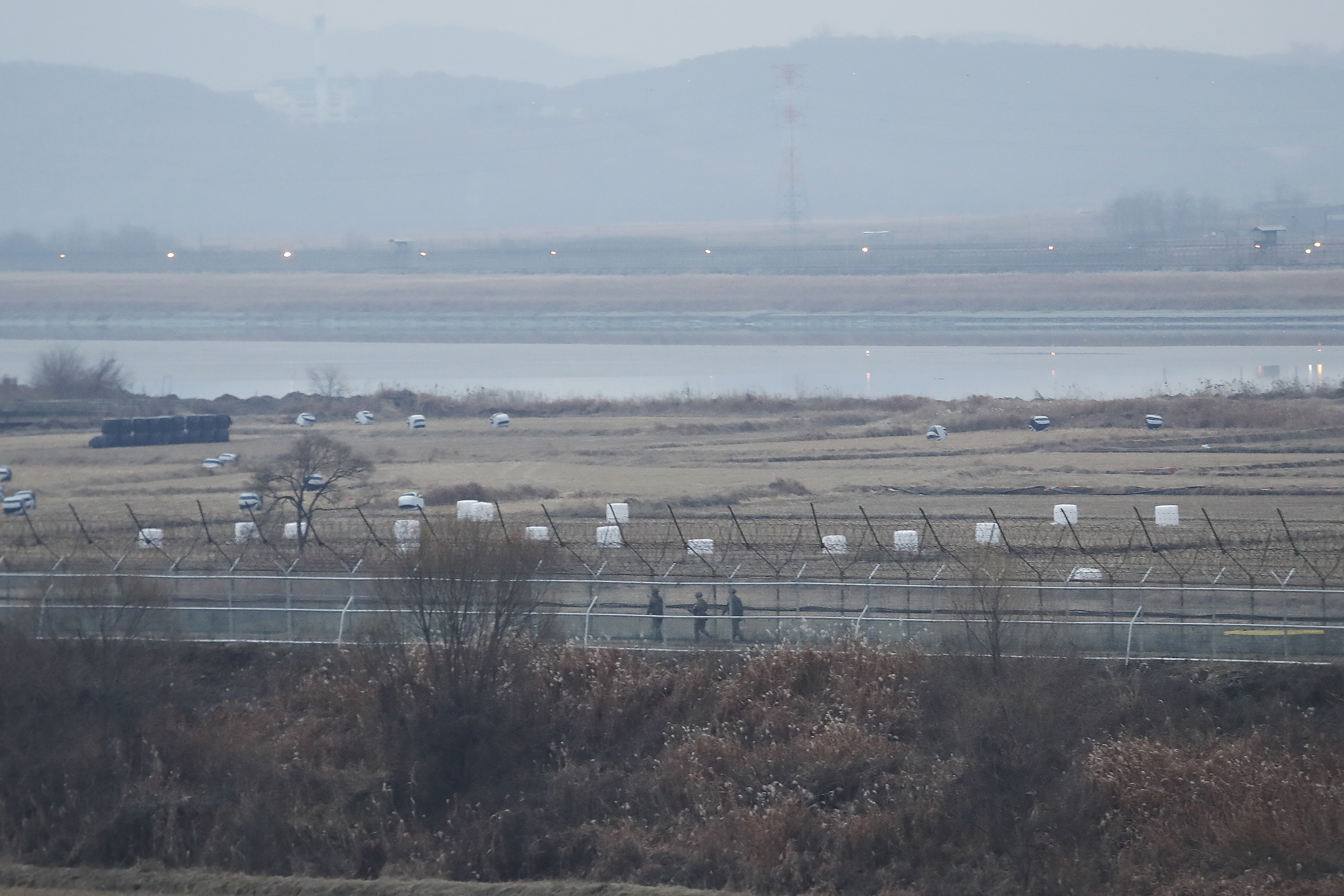 In this December 2019 photo, South Korean army soldiers patrol along the barbed-wire fence in Paju, South Korea, near the border with North Korea.