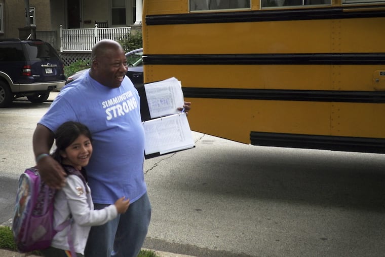 Lenny Robinson, one of the founders of the Wissahickon Cares Homework Club, hugs a student who comes off the bus to attend Homework Cares in Ambler, Pa.