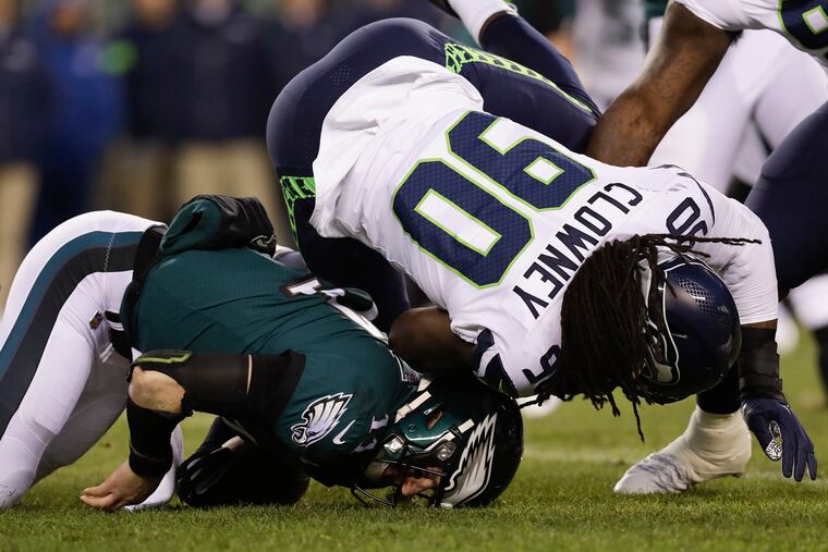 Carson Wentz falls on the turf after getting hit by Jadeveon Clowney during last Sunday's playoff game. Wentz suffered a concussion on the play.