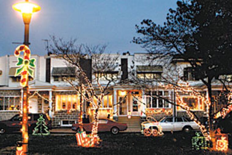 Neighbors in the 1700 block of Smedley Street in South Philadelphia pool resources to light up their street. (BONNIE WELLER/Inquirer)