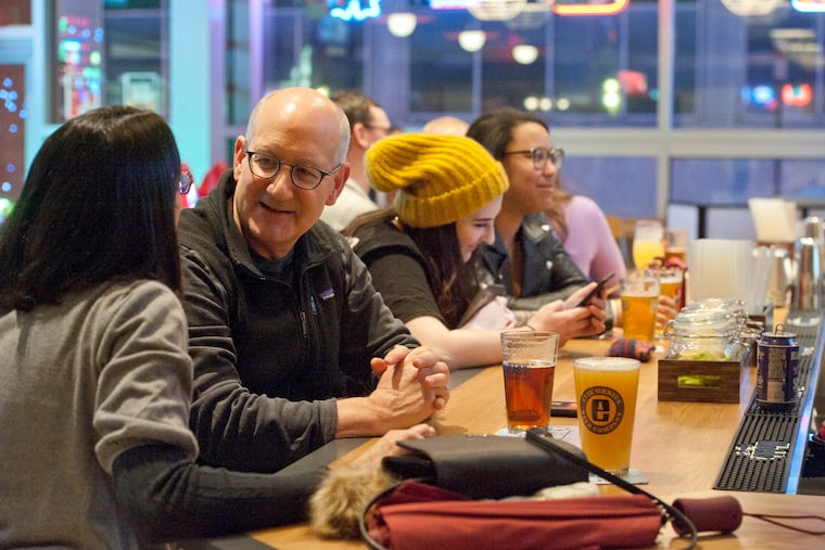 Patrons enjoy good drink and conversation at the bar of the The Post at Cira Garage in West Philadelphia, February 23, 2019.